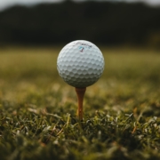 Close-up of a golf ball on a tee in the grass.