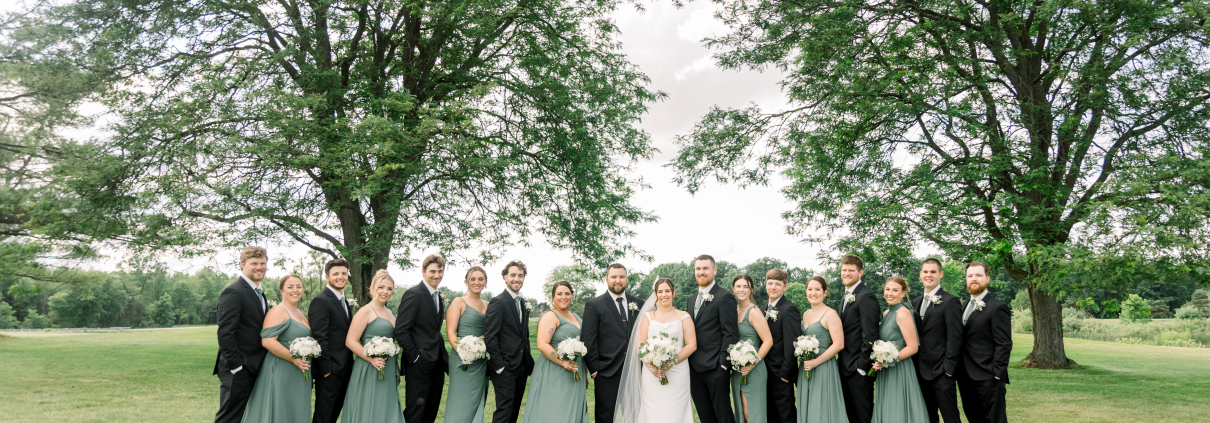 Wedding party in elegant attire outdoors.